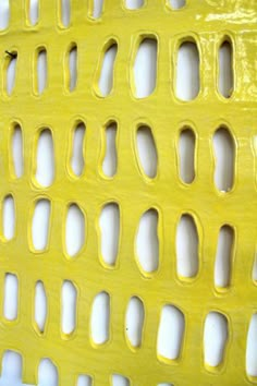 a yellow plastic bench with holes in it