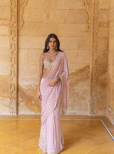 a woman in a pink sari posing for the camera