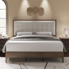 a bedroom with a bed, nightstands and two lamps on either side of the bed