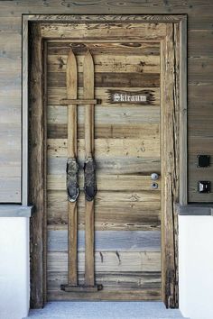 a pair of skis are propped up against a wooden door