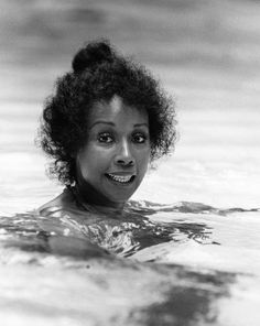 an old photo of a woman swimming in the water