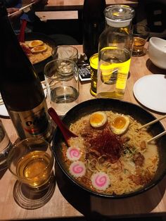 a bowl of ramen with two boiled eggs in it and chopsticks sticking out