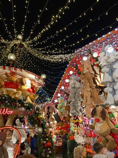 many stuffed animals are hanging from the ceiling in this christmas display at an amusement park