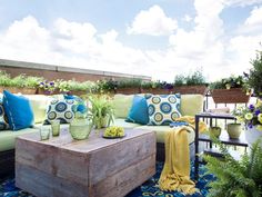 an outdoor living area with couches, tables and potted plants