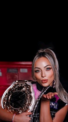 a woman holding a large metal object in her right hand and posing for the camera