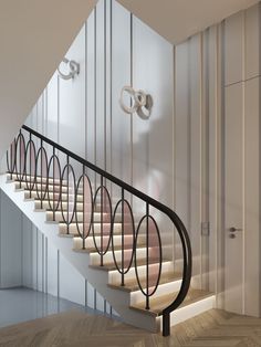 a stair case next to a white wall and wooden floor with metal handrails