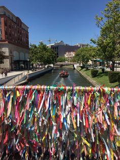 a boat traveling down a river filled with lots of colorful stream ribbons hanging from it's side