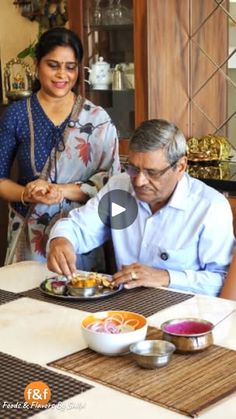 two people sitting at a table eating food