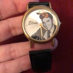 a hand holding a watch with elvis on it