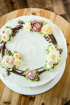 a cake decorated with flowers on top of a wooden table