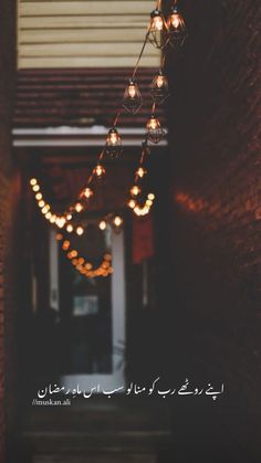 an image of lights hanging from the ceiling in front of a building with arabic writing on it