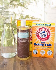 a bottle of baking soda next to a glass vase and box of baking soda on a table