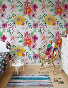 a bedroom with floral wallpaper and colorful rugs