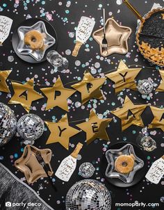 a black table topped with lots of different types of party decorations and confetti