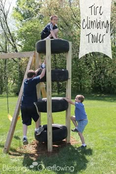 two boys are climbing up a wooden ladder to climb on tires and another boy is holding onto the tire