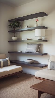 a living room with two couches and some shelves on the wall above them,