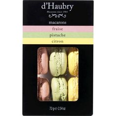 four different colored macarons are in a card board box on a white background