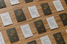 many business cards are arranged on a wooden surface with orange and black lettering that says yes