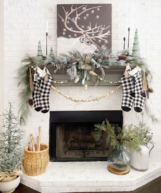 a fireplace decorated for christmas with stockings and pine cones