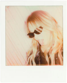 a polaroid photograph of a blonde haired girl with sunglasses