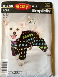 a small white dog wearing a black polka dot shirt on top of a magazine cover