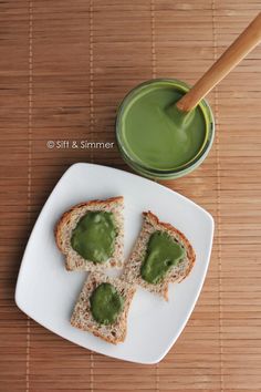 a white plate topped with pieces of bread covered in green sauce