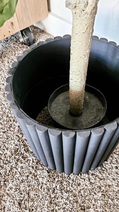 a cement planter with a tree in it's center on the ground next to a door