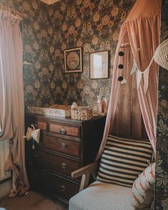 a baby's crib in the corner of a room with floral wallpaper