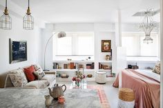 a living room filled with lots of furniture next to a window covered in light colored curtains