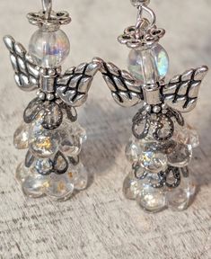 Super cute angel earrings!! Handcrafted using clear Czech glass flower beads with gold flecks and gunmetal tone brass filigree bead caps as the dresses, antique silver plated angel wings and halos, iridescent clear round glass beads as the heads and silver plated ear wires!! Great for Christmas, baptisms, Easter, communions or any special spiritual occasions!! Length 2" Beaded Bottles, Flower Angel, Brass Filigree, Angel Earrings, Special Occasion Jewelry, Silver Wings, Gold Flecks, Flower Beads, Christmas Earrings