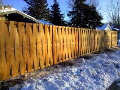 a wooden fence with snow on the ground