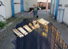 a young boy standing on top of a giant piece of art in the middle of an alley