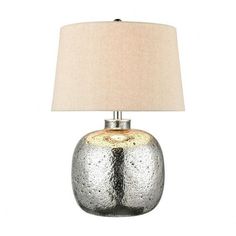 a table lamp with a white shade on top of it and a silver vase in the middle