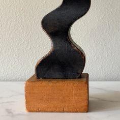 a wooden sculpture sitting on top of a white counter