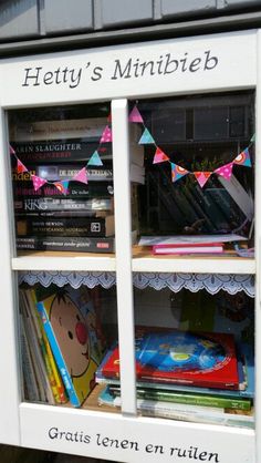 there is a book case with many books in it and bunting on the front