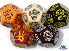 five different colored dices with black and yellow lettering on them, all in various designs