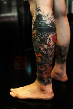 a man's legs with tattoos on them and an image of a koi fish