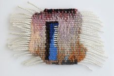 a multicolored piece of woven material with fringes