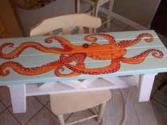 an octopus painted on the side of a table with chairs around it and a chair in the background