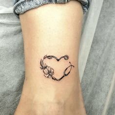 a small tattoo on the ankle of a woman's foot with a heart and flowers