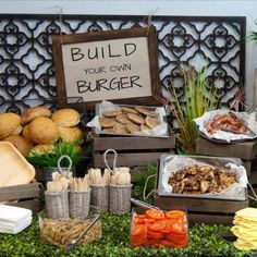 an assortment of food on display at a buffet table with a sign that says build your own burgerer