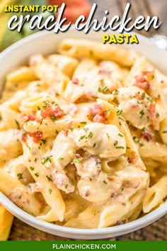 a white bowl filled with pasta covered in chicken and sauce on top of a wooden table