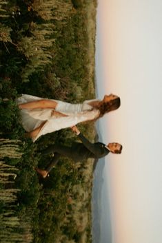 two people standing next to each other in the grass