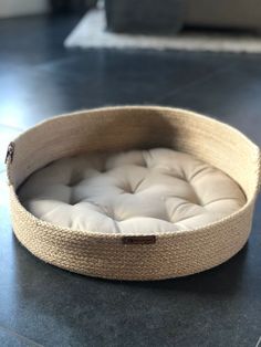 a dog bed made out of rope on the floor