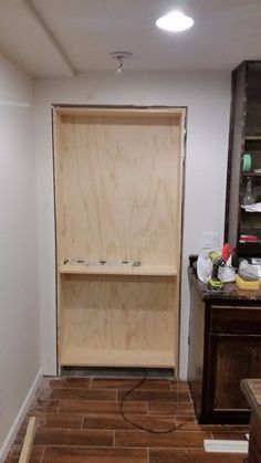 an empty room with wooden shelves and hard wood flooring on the ground in front of it