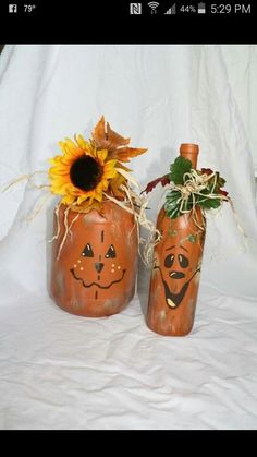 two pumpkins decorated with faces and sunflowers are sitting next to each other