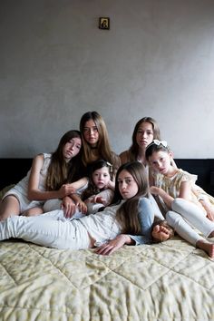 a group of young women sitting on top of a bed