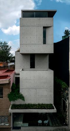 the house is made up of concrete blocks and has plants growing on top of it