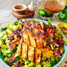 a salad with grilled tofu, corn and avocado on the side