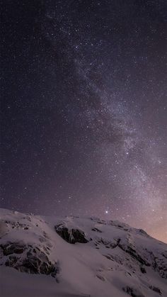 the night sky is filled with stars above snow covered mountains